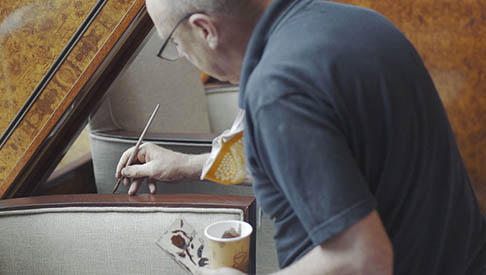 worker paints trim on qm2